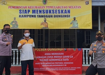 Pemasangan baliho di kawasan zona merah oleh Polsek Dungingi,