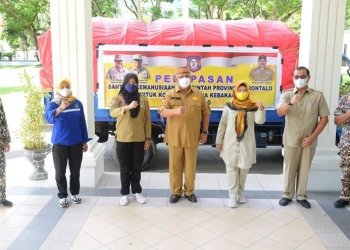 Gubernur Rusli Habibie didampingi Ketua TPKK provinsi Gorontalo Idah Syahidah dan Kadis Sosial saat melepas anggota tagana untuk menyalurkan bantuan bagi korban kebakaran di Kelurahan Bitung Tengah, Kecamatan Maesa, Kota Bitung, Sulawesi Utara,  Selasa (6/7/2021) . Foto – Salman