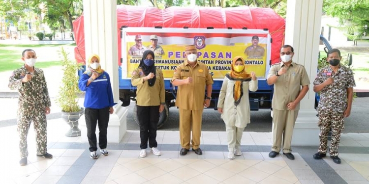 Gubernur Rusli Habibie didampingi Ketua TPKK provinsi Gorontalo Idah Syahidah dan Kadis Sosial saat melepas anggota tagana untuk menyalurkan bantuan bagi korban kebakaran di Kelurahan Bitung Tengah, Kecamatan Maesa, Kota Bitung, Sulawesi Utara,  Selasa (6/7/2021) . Foto – Salman