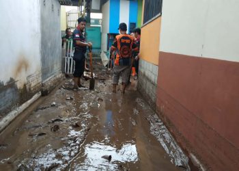 Tim BPBD Bone Bolango bersama pihak terkait saat membersihkan sisa lumpur akibat banjir yang menerjang Desa Huangobotu Kecamatan Kabila Bone. (Foto Istimewa)