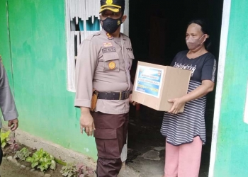 Kapolres Bone Bolango, AKBP Emile Reisitei Hartanto saat menyerahkan paket bantuan sembako kepada masyarakat. (Foto Humas Polres Bone Bolango)