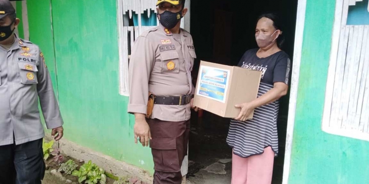 Kapolres Bone Bolango, AKBP Emile Reisitei Hartanto saat menyerahkan paket bantuan sembako kepada masyarakat. (Foto Humas Polres Bone Bolango)