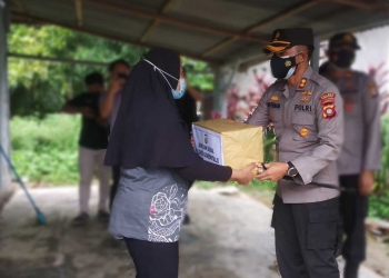 Kapolres Gorontalo, AKBP Ade Permana saat memberikan bantuan kepada salah seorang warga di Kelurahan Bongohulawa Kecamatan Limboto Kabupaten Gorontalo, Jumat (16/7/2021). (Foto: Putra/Gopos)