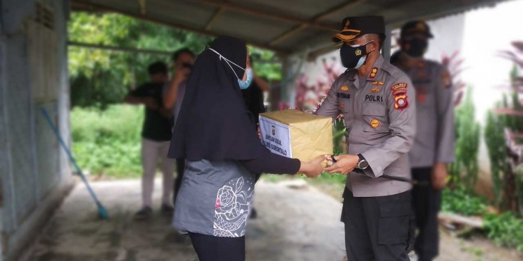 Kapolres Gorontalo, AKBP Ade Permana saat memberikan bantuan kepada salah seorang warga di Kelurahan Bongohulawa Kecamatan Limboto Kabupaten Gorontalo, Jumat (16/7/2021). (Foto: Putra/Gopos)