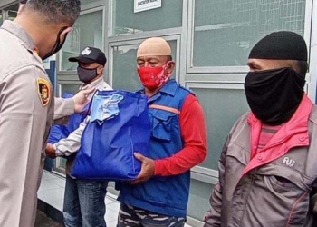 Kapolres Blitar, AKBP Leonard M Sinambela (tampak dari belakang) membagikan paket sembako kepada pengendara ojek online. (Foto: istimewa)