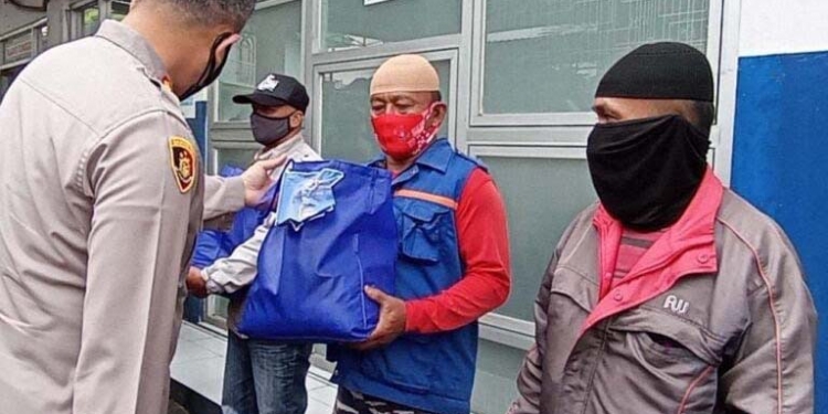 Kapolres Blitar, AKBP Leonard M Sinambela (tampak dari belakang) membagikan paket sembako kepada pengendara ojek online. (Foto: istimewa)