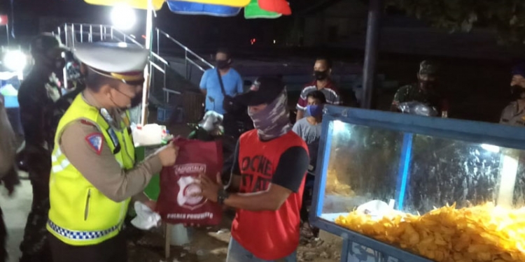 Pembagian sembako bagi pedagang yang ada di seputaran objek wisata Pohon Cinta, Marisa, Pohuwato. (mahmud/gopos)