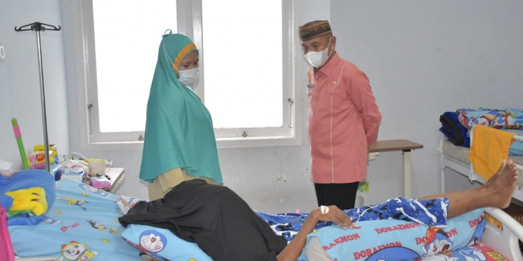 Bupati Pohuwato, Saipul Mbuinga, menjenguk pasien penderita tumor asal Desa Buntulia Barat, Kecamatan Duhiadaa, Kabupaten Pohuwato yang dirawat di RSAS, Kota Gorontalo, Kamis (5/8/2021). (Istimewa)