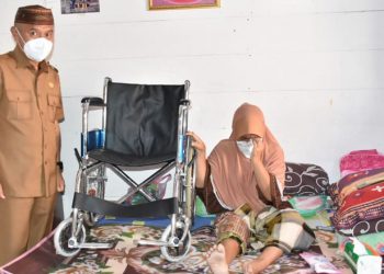 Bupati Pohuwato, Saipul Mbuinga, saat menyambangi sekaligus menyerahkan kursi roda kepada Salma Saleh yang mengalami kecelakaandan tak bisa berjalan lagi. (istimewa)