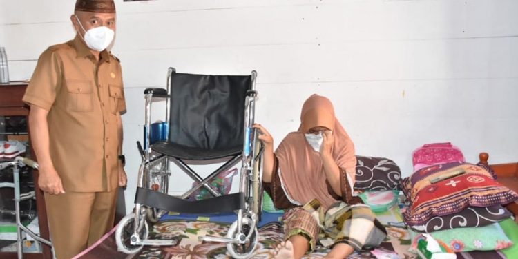 Bupati Pohuwato, Saipul Mbuinga, saat menyambangi sekaligus menyerahkan kursi roda kepada Salma Saleh yang mengalami kecelakaandan tak bisa berjalan lagi. (istimewa)