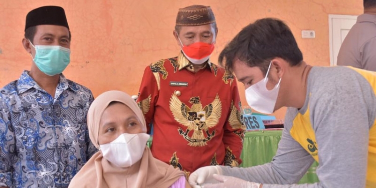 Bupati Pohuwato (batik merah), Saipul Mbuinga, menyaksikan proses penyuntikan vaksin Covid-19 kepada warga di Desa Sipatana, Kecamatan Buntulia, Kabupaten Pohuwato, Jumat (13/8/2021).