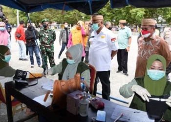 Gubernur Gorontalo, Rusli Habibie (kiri) bersama Wali Kota Gorontalo, Marten Taha (kanan), meninjau pelaksanaan vaksinasi di Tempat Vaksinasi Serentak (TVS) Lapangan Taruna Remaja Kota Gorontalo, Rabu (12/8/2021). (Kominfo Prov. Gorontalo)