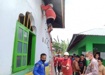 Petugas pemadam kebakaran Kabupaten Gorontalo berusaha memadamkan api yang membesar dari bagian gudang masjid, Jumat (20/8/2021).