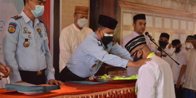 Kasdin Lato, Kepala Satuan Pengamanan Lapas Kelas II A Gorontalo sedang menyerahkan penghargaan kepada para warga binaan yang menuntaskan bacaan Al-Qur'an, Kamis (12/8/2021) foto : Humas