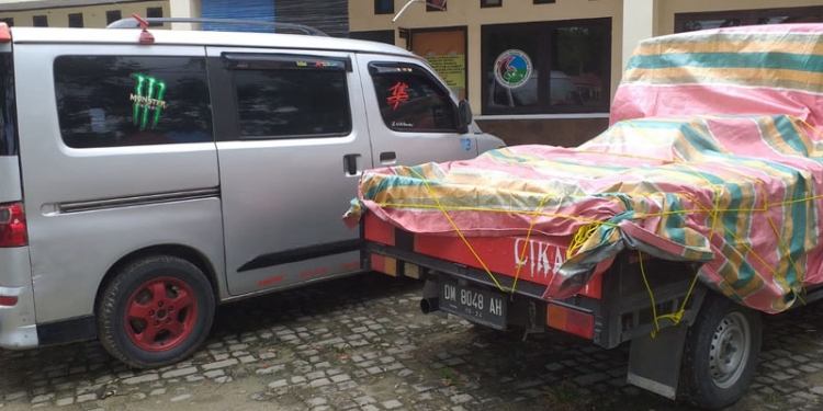Dua unit mobil yang mengangkut miras jenis cap tikus seberat 1,5 ton saat diamankan di Satnarkoba Polres Bone Bolango. (Indra/Gopos)