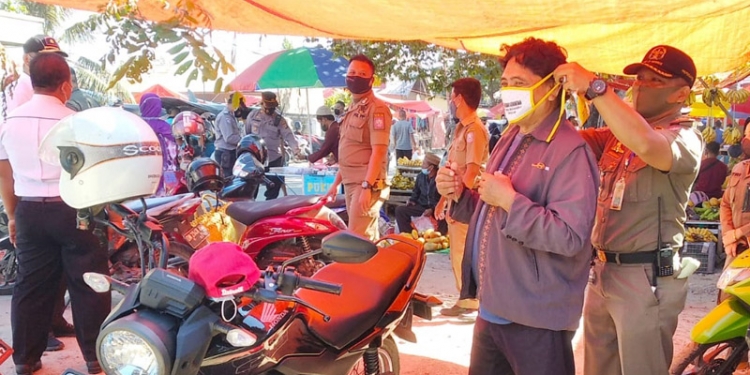 Aparatur Pemprov Gorontalo melakukan pembagian masker sekaligus edukasi untuk patuh terhadap protokol kesehatan. (dok. Kominfo Prov.Gorontalo)