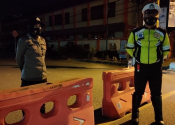 Personel Polres Gorontalo Kota melakukan penjagaan dalam kegiatan penyekatan sejumlah ruas jalan di Kota Gorontalo untuk mengurangi mobilitas warga. (dok. Polres Gorontalo Kota)