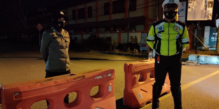 Personel Polres Gorontalo Kota melakukan penjagaan dalam kegiatan penyekatan sejumlah ruas jalan di Kota Gorontalo untuk mengurangi mobilitas warga. (dok. Polres Gorontalo Kota)