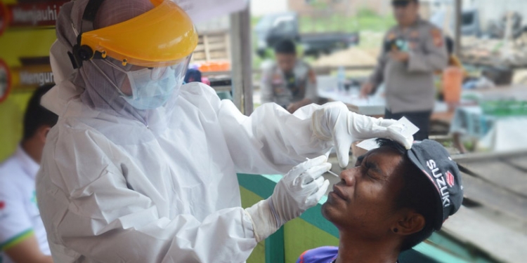 Salah seorang masyarakat yang berkunjung ke Pasar Hulawa Desa Hulawa Kecamatan Telaga Kabupaten Gorontalo di vaksinasi Covid-19, Jumat (6/8/2021). (Foto: Putra/Gopos)