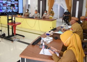 Gubernur Gorontalo Rusli Habibie (tengah) saat memimpin rapat virtual dengan Forkopimda, Bupati, Wali Kota serta perwakilan camat dan desa, Selasa (10/8/2021). Foto – Salman)