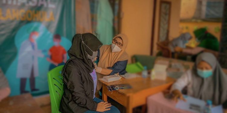 Salah seorang warga di pasar Sukamakmur Desa Molohu Kecamatan Tolangohula Kabupaten Gorontalo saat di vaksinasi, Kamis (12/8/2021), Foto : Putra/Gopos.