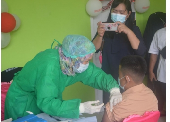 Cristian Ginting (13) siswa yang duduk dibangku kelas VIII bersama ibunya saat melaksanakan vaksinasi Covid-19 di SMP Negeri 1 Telaga Biru, Rabu (25/8/2021) Foto : Putra/Gopos.