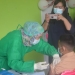 Cristian Ginting (13) siswa yang duduk dibangku kelas VIII bersama ibunya saat melaksanakan vaksinasi Covid-19 di SMP Negeri 1 Telaga Biru, Rabu (25/8/2021) Foto : Putra/Gopos.