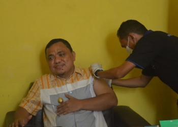 Ketua DPD II Partai Golkar Kabupaten Gorontalo, Hendra S Hemeto saat disuntik vaksin Covid-19, di Kantor DPD II Golkar Kabupaten Gorontalo, Selasa (3/8/2021). (Foto: Putra/Gopos)