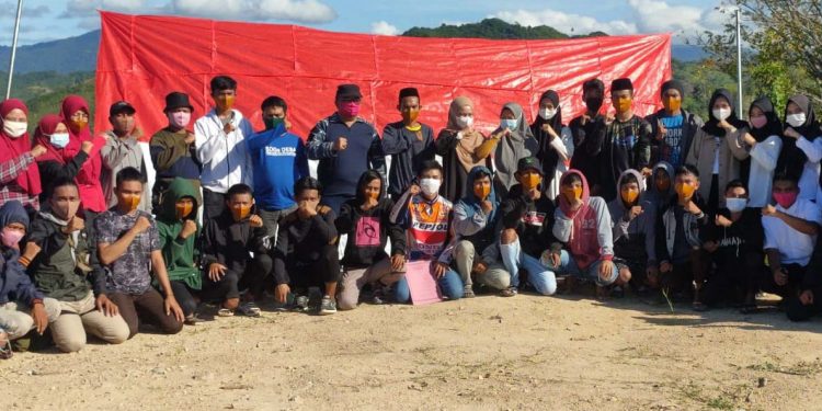 Karang Taruna Mo'owata Desa Bendungan, Kecamatan Mananggu, Kabupaten Boalemo bersama Pemerintah Desa Bendungan sesaat setelah melakukan pengibaran bendera merah putih yang terbuat dari karung, di Puncak Bukit Bulalo Lambu Desa Bendungan. Selasa (17/8/2021). (Foto istimewa)