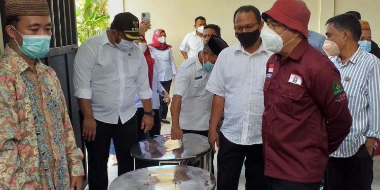 Bupati Bone Bolango, Hamim Pou saat meninjau proses produksi handsanitizer yang berasal dari bahan cap tikus oleh Sentra IKM Bioetanol Desa Lonuo Kecamatan Tilongkabila. (Foto Indra/Gopos)