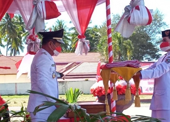 Bupati Pohuwato, Saiful A Mbuinga Saat menyerahkan Bendera Merah Putih kepada pasukan Paskibraka yang mengibarkan Bendera Merah Putih. (Foto: Mahmud/Gopos)