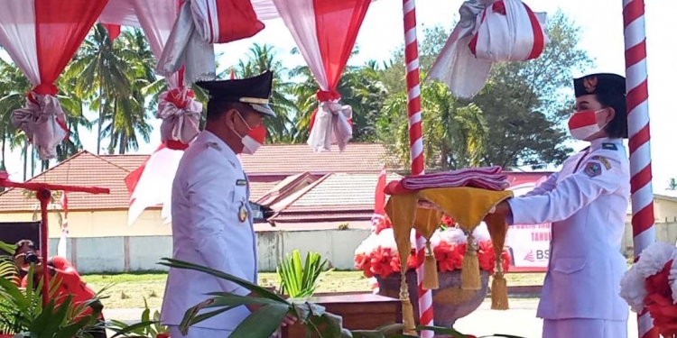 Bupati Pohuwato, Saiful A Mbuinga Saat menyerahkan Bendera Merah Putih kepada pasukan Paskibraka yang mengibarkan Bendera Merah Putih. (Foto: Mahmud/Gopos)