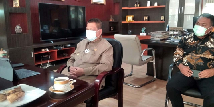 Wagub Gorontalo Idris Rahim (kiri) mengikuti peluncuran sistem OSS Berbasis Risiko di ruang kerjanya di Gubernuran Gorontalo, Senin (9/8/2021). (Foto: Kominfo)