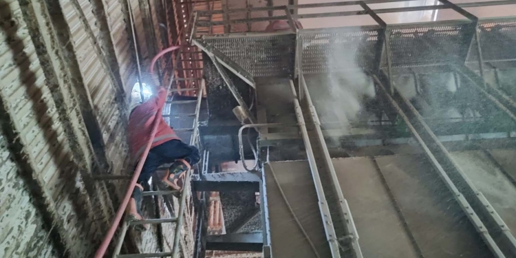 Petugas pemadam kebarakan Kabupaten Gorontalo, saat mencoba memadamkan api pada satu unit alat pengering jagung (mesin drayer) di pabrik jagung PT Sinar Pangan Abadi, Desa Pulubala, Kecamatan Pulubala, Kabupaten Gorontalo, Rabu (18/8/2021). (Foto istimewa)