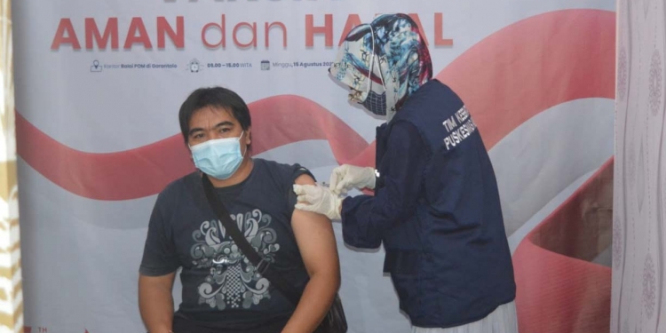 VAKSINASI COVID-19 -  Salah seorang masyarakat saat melaksanakan vaksinasi Covid-19 di Kantor BPOM Gorontalo, Minggu (15/8/2021). (Foto: Putra/Gopos)