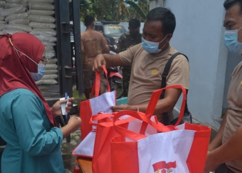 Sejumlah masyarakat terlihat menerima bantuan beras yang diberikan pihak Kepolisian usai melaksanakan vaksinasi di Halaman belakang Kantor Desa Yosonegoro, Kecamatan Limboto Barat, Kabupaten Gorontalo, Kamis (23/9/2021). Foto : Putra/Gopos.