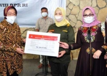 Mensos Risma (kiri) menyerahkan bantuan ATENSI kepada Anggota Komisi VIII DPR RI, Idah Syahidah Rusli Habibie (tengah), di Angelato Resto & Cafe, Kota Gorontalo, Kamis (30/9/2021). (Foto: Haris)