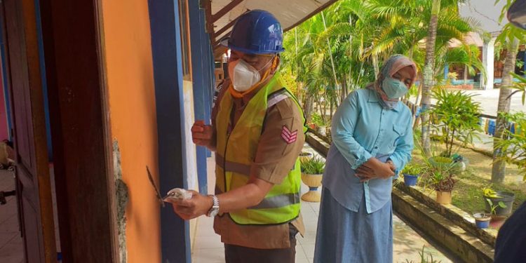 Bupati Bone Bolango, Hamim Pou didampingi Kepala Dinas Pendidikan dan Kebudayaan Marni Nisabu saat menghadiri peletakan batu pertama pembangunan rehabilitasi sembilan ruang kelas, ruang tata usaha, dan jamban SMP Negeri 2 Suwawa. (Foto Indra/Gopos)