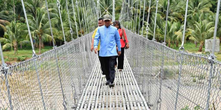Bupati Saipul A. Mbuinga didampingi Kepala Baperlitbang, Irfan Saleh, Camat Popayato, Kadir Amran dan Kepala Bidang (Kabid) Bina Marga, Risdiyanto Mokodompit saat melakukan peninjauan jembatan gantung di Desa Tunas Harapan.