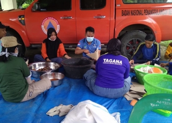 Anggota Tim Tagana dan BPBD Pohuwato menyiapkan makanan siap saji untuk diidstribusikan bagi warga terdampak banjir. (istimewa)