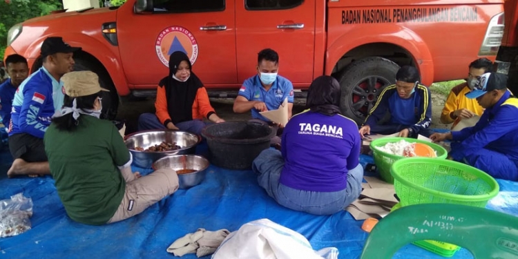 Anggota Tim Tagana dan BPBD Pohuwato menyiapkan makanan siap saji untuk diidstribusikan bagi warga terdampak banjir. (istimewa)