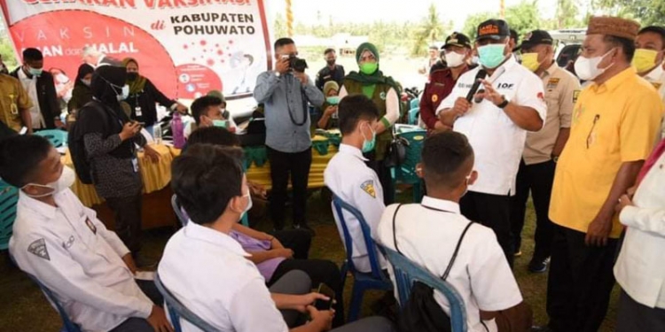 Gubernur Gorontalo, Rusli Habibie, memberi motivasi kepada siswa pada pelaksanaan vaksinasi massal di wilayah Kabupaten Pohuwato. (dok. Kominfo Prov. Gorontalo)