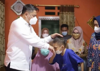 Bupati Hamim Pou saat menjenguk Safran anak penderita tumor ganas di Kelurahan Pauwo Kecamatan Kabila. (Foto Istimewa)