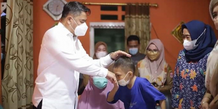 Bupati Hamim Pou saat menjenguk Safran anak penderita tumor ganas di Kelurahan Pauwo Kecamatan Kabila. (Foto Istimewa)