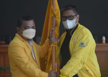 Ketua DPD II Golkar Kabupaten Gorontalo terpilih, Hendra S Hemeto (kiri) menerima bendera Golkar yang diserahkan Pimpinan Sidang Musda X DPD II Golkar Kabupaten Gorontalo, Maman Dzakaria. (Foto : Putra/Gopos)