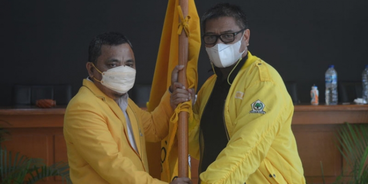 Ketua DPD II Golkar Kabupaten Gorontalo terpilih, Hendra S Hemeto (kiri) menerima bendera Golkar yang diserahkan Pimpinan Sidang Musda X DPD II Golkar Kabupaten Gorontalo, Maman Dzakaria. (Foto : Putra/Gopos)