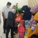 Ketua Tim Penggerak PKK Kabupaten Bone Bolango Lolly Pou Yunus didampingi Ketua Bidang IV Roos Panai, Camat Bulango Selatan, Sukriyanto Katili, saat menyerahkan bantuan Pemberian Makanan Tambahan (PMT) bagi anak yang dilaksanakan di Huntu Selatan Training Center. (Foto Istimewa)