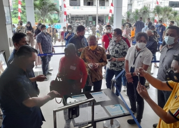 Pengecekan kartu vaksinasi bagi warga yang hendak masuk ke Mall Gorontalo. Selain itu pengujung diwajibkan melakukan scan QR aplikasi Peduli Lindungi, Sabtu (18/9/2021). (putra/gopos)