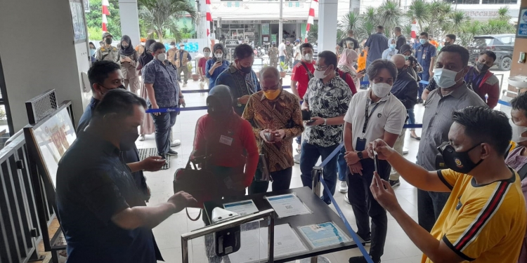 Pengecekan kartu vaksinasi bagi warga yang hendak masuk ke Mall Gorontalo. Selain itu pengujung diwajibkan melakukan scan QR aplikasi Peduli Lindungi, Sabtu (18/9/2021). (putra/gopos)