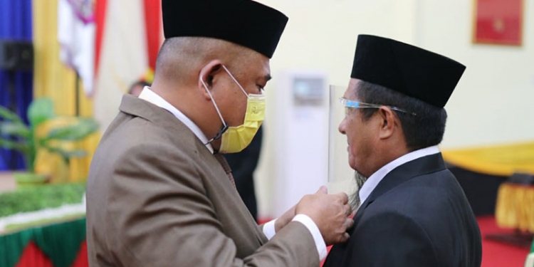 Ketua DPRD Pohuwato, Nasir Giasi, menyematkan PIN Anggota DPRD Pohuwato kepada Ihwan Khan yang dilantik sebagai PAW DPRD Pohuwato periode 2019-2024, Selasa (21/9/2021)